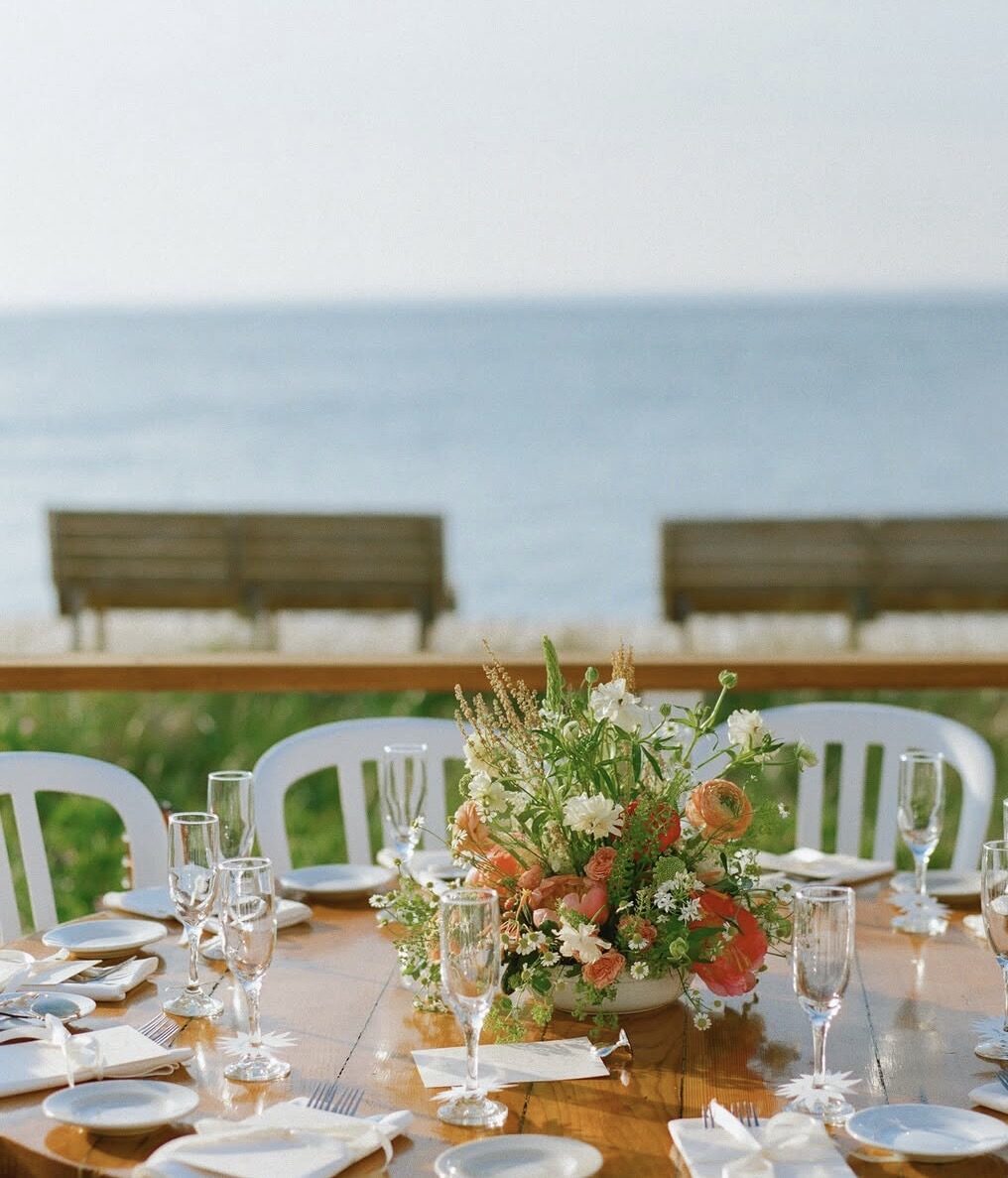 Long dinner table with florals overlooking the bay