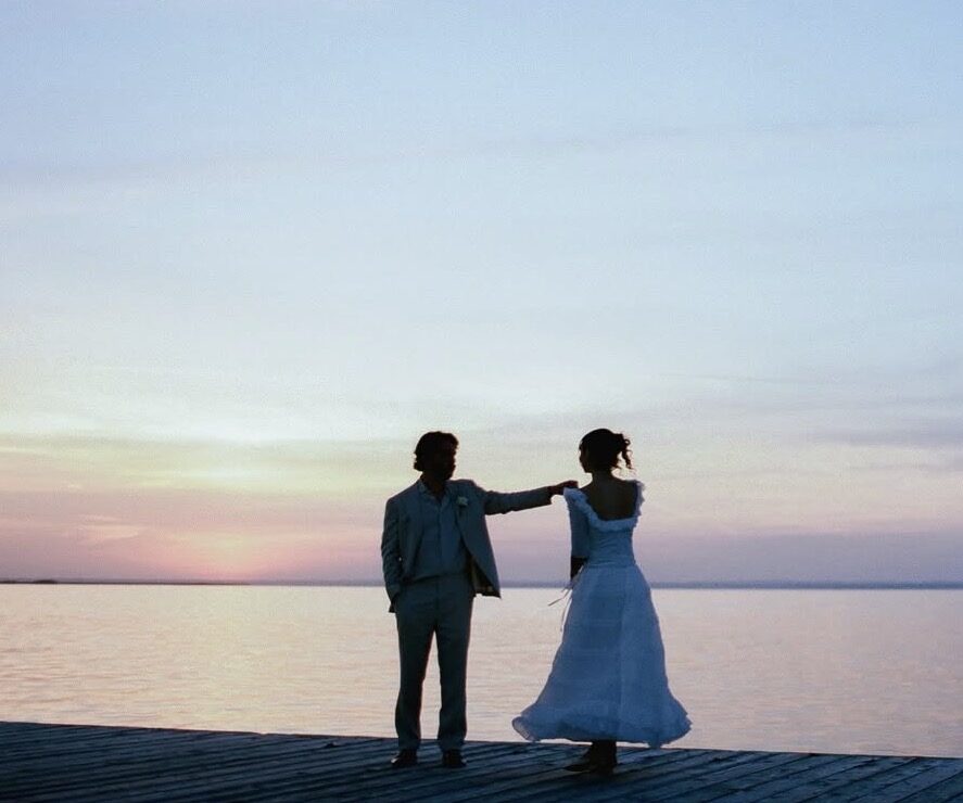 Bride and groom on the dock at sunset