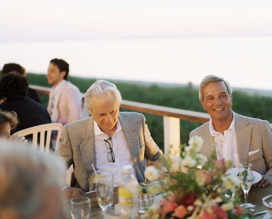 Dinner guests seated at a flower-topped table