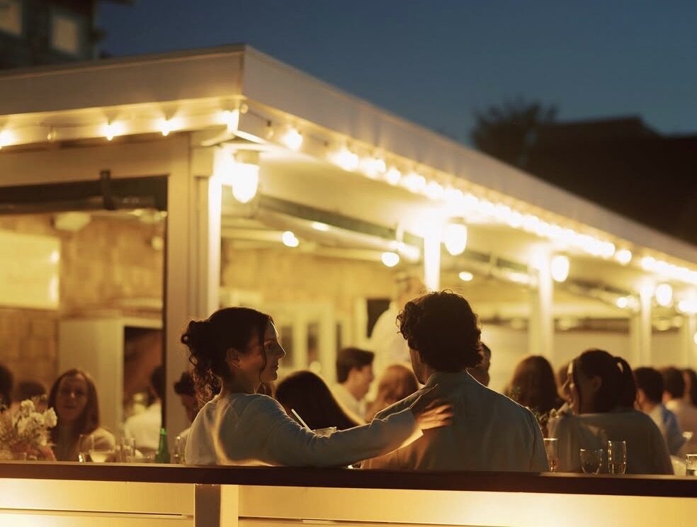 String-lit deck at night with a couple in silhouette